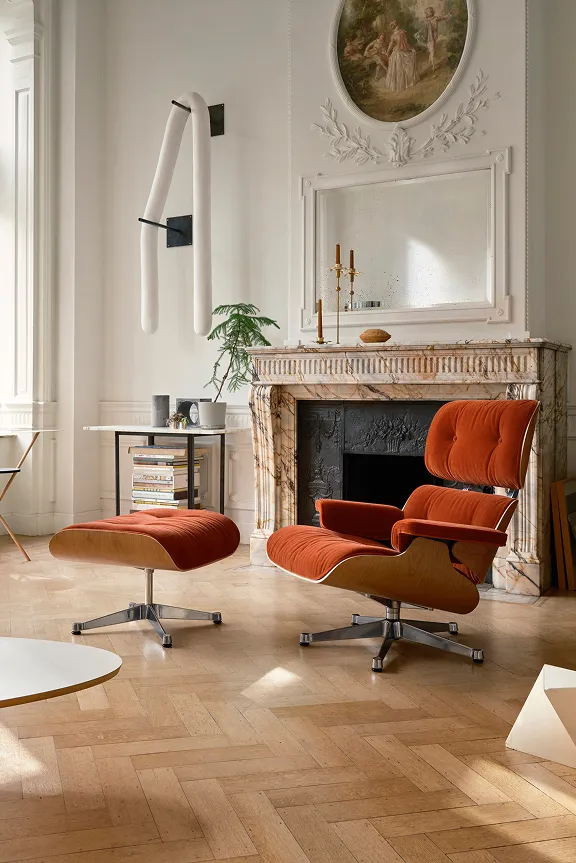 Helles Wohnzimmer mit Stuckdecke, Eames Lounge Chair in Rostrot, Kamin, Kunst und Parkett.